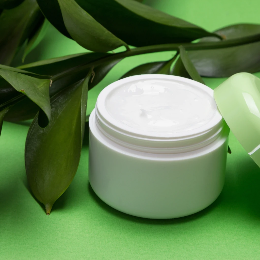 Imagem de um pote de creme sobre um fundo verde ilustrando o texto Tipos de cosméticos naturais
