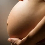 Close em uma barriga de uma mulher grávida ilustrando o texto Pele na gravidez: principais mudanças e cuidados durante a gestação