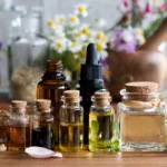 Imagem com diversos frascos de diferentes óleos naturais e essenciais com flores ao fundo de forma desfocada